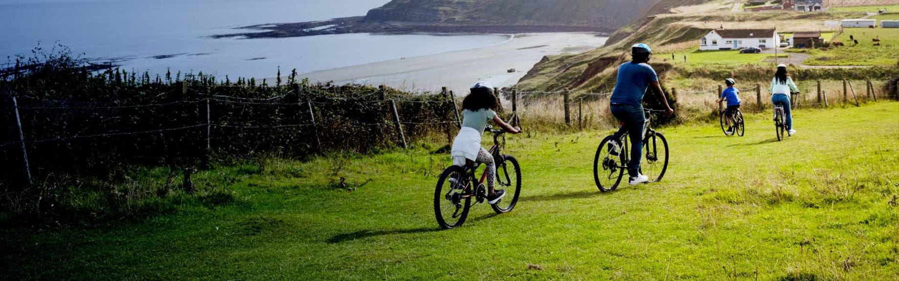 family on a bike ride overlooking a beach