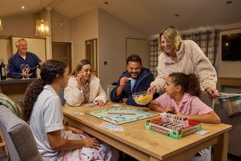 A family playing board games while on holiday in a lodge