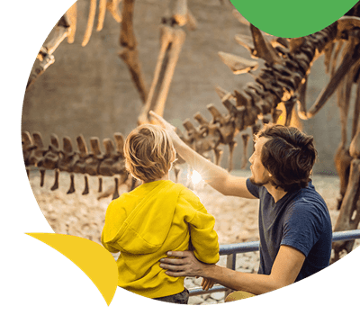 A father and son looking at a dinosaur fossil in a museum