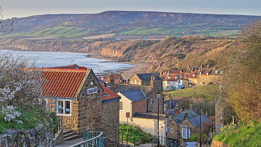 A view over the rooftops of Robin Hoods Bay, with the Yorkshire Coast in the background