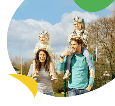 A family walking through a holiday park wearing Easter hats