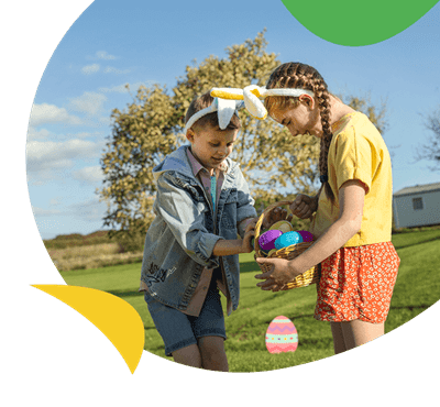 Siblings taking part in an Easter egg hunt on a holiday park
