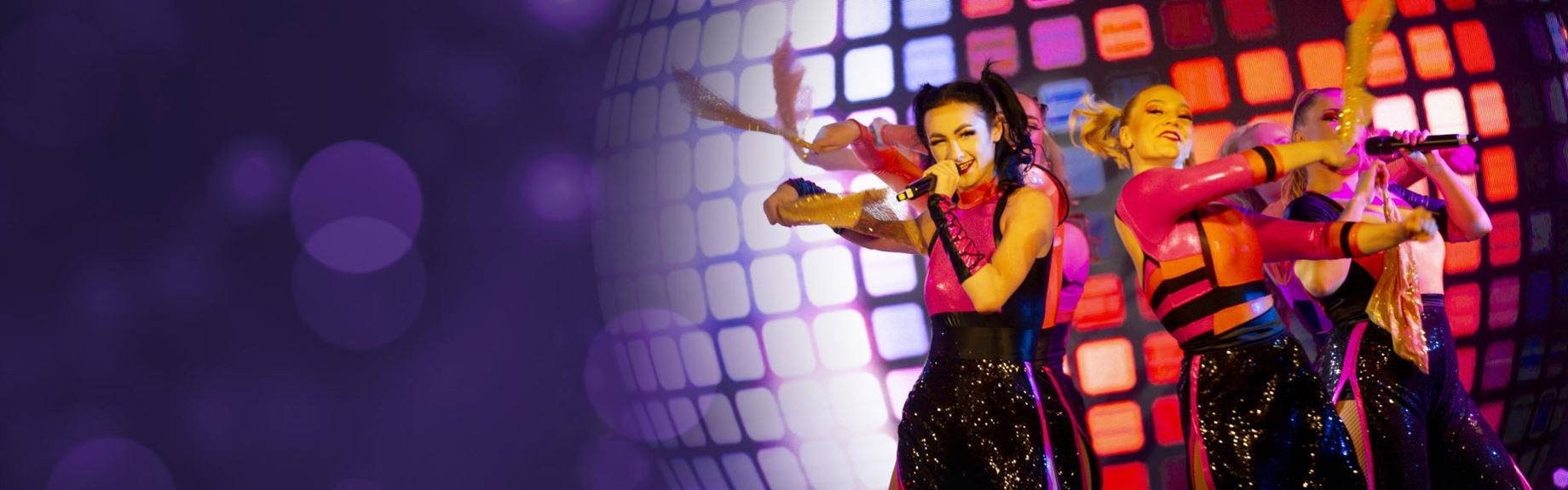 Group of women dancing on stage at Parkdean Resorts