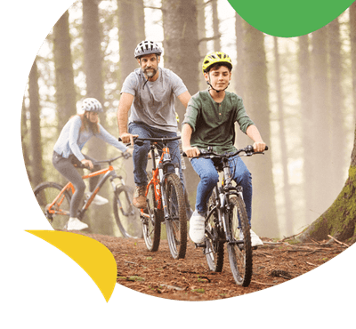 A family cycling through the woods