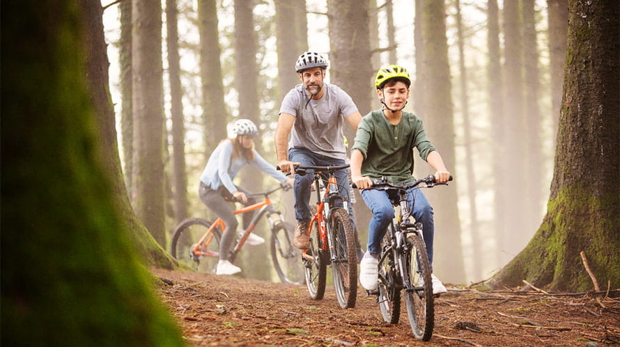 A family cycling through the forest