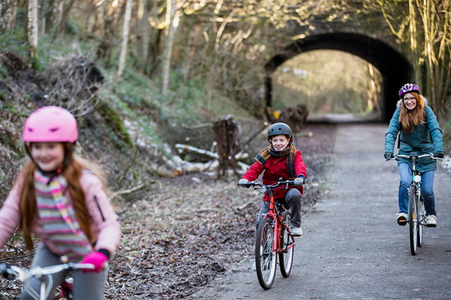A family cycling along a bike trail