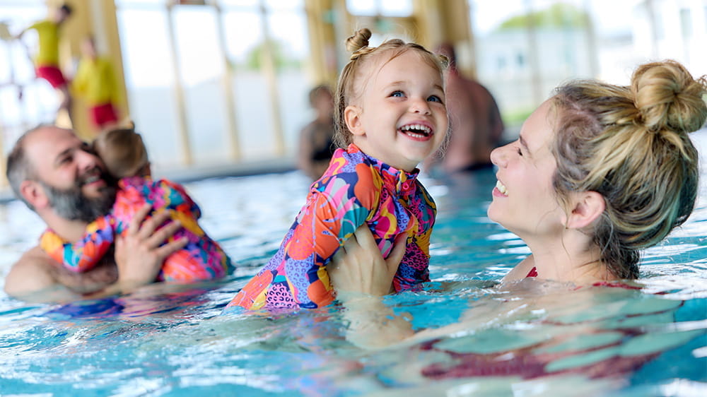 A family enjoying a swimming session in an indoor pool