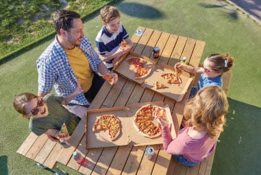 Family enjoying pizza in the sunshine at Parkdean Resorts