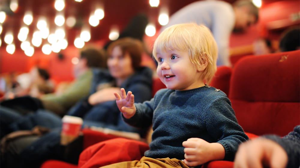A little boy enjoying watching a film in a cinema