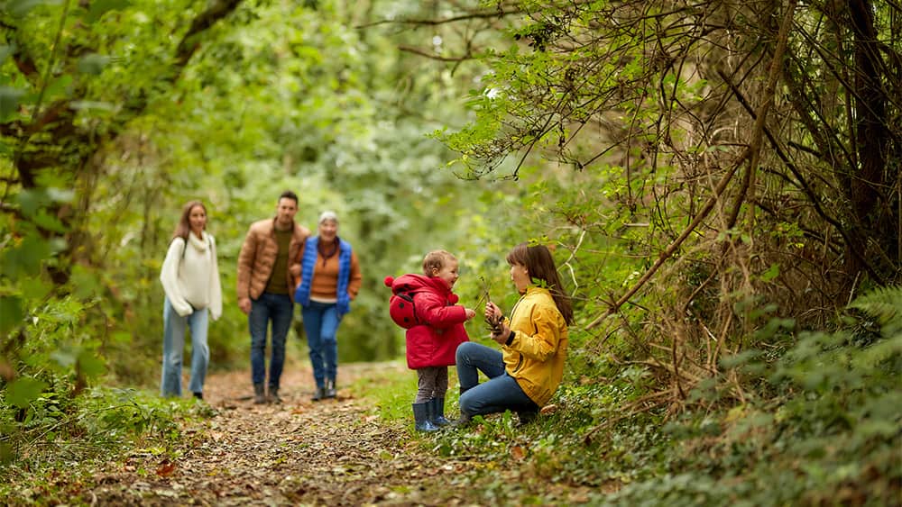 A family walking through the woods on an autumn day