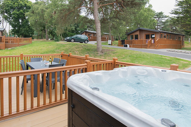 A hot tub on the decking of a lodge