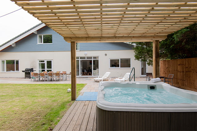 The garden and hot tub outside Amberwood House at Sandford Holiday Park