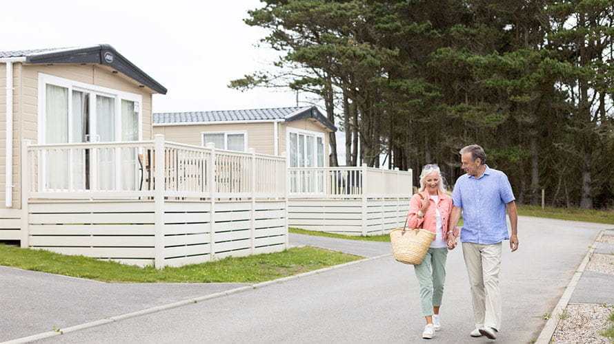 A couple walking past a row of static caravans