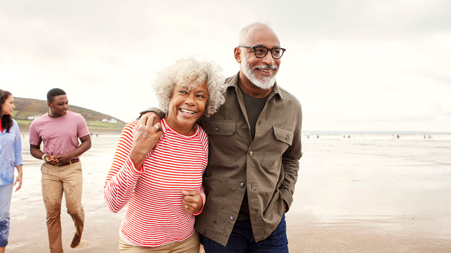 An elderly couple enjoying a walk on the beach