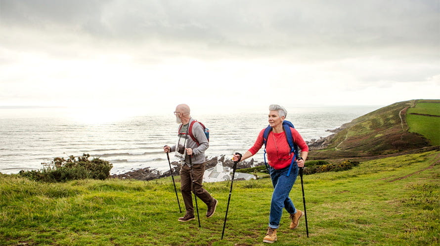 An older couple hiking along a coastal path