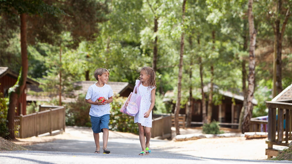 Kids walking through the woodland setting of Warmwell Holiday Park in Dorset