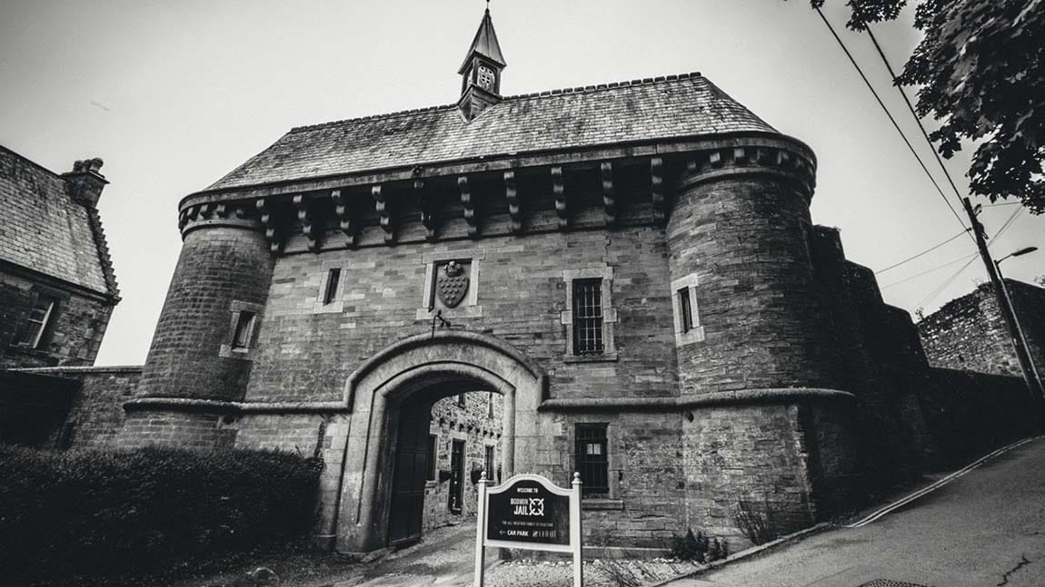 A dramatic black and white photo of the gates of Bodmin Jail in Cornwall