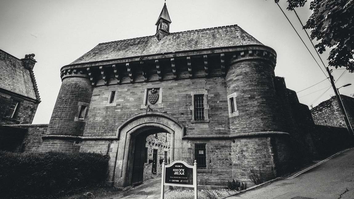 A dramatic black and white photo of the gates of Bodmin Jail in Cornwall