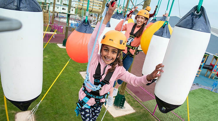 A family enjoying the high ropes course at Cayton Bay Holiday Park