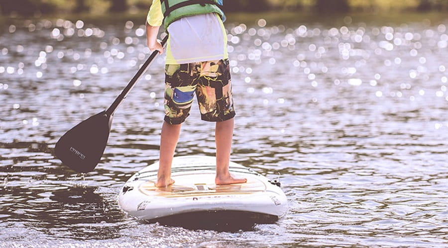 A boy paddle boarding