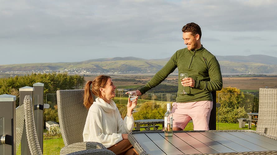 A couple enjoying drinks on their lodge veranda