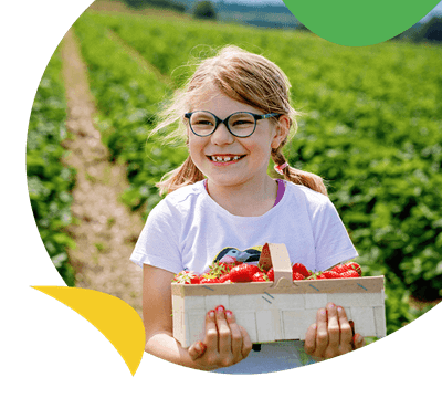 A girl carrying a basket of strawberries at a PYO farm