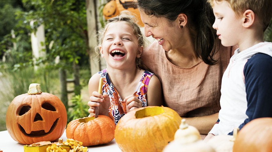 A family enjoying carving Halloween pumpkins