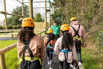 Teenages wearing helmets and harnesses, about to do the high ropes course on a Parkdean holiday