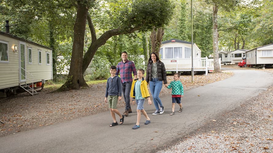 A family walking past caravans at St Minver in Cornwall