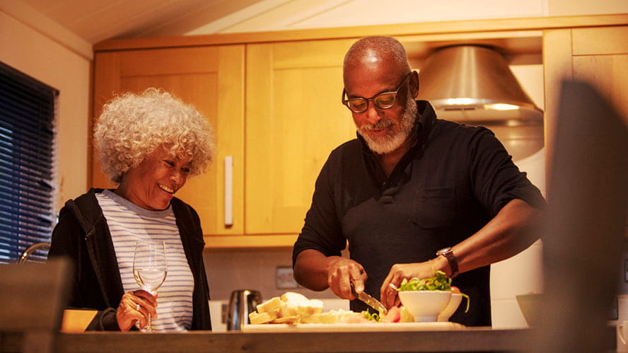 A couple cooking dinner in a caravan kitchen
