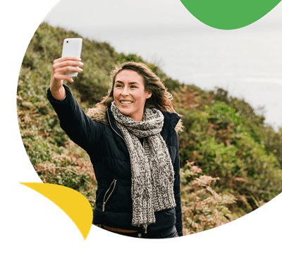 A woman talking a selfie on a walk in the countryside
