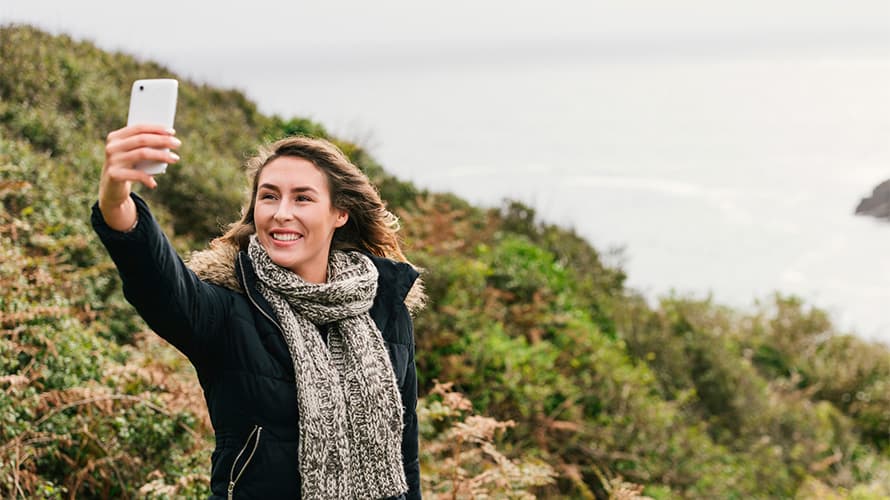 A woman taking a selfie while on a walking trail