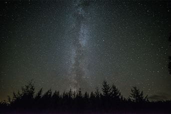 The milky way and stars shining above Kielder Forest