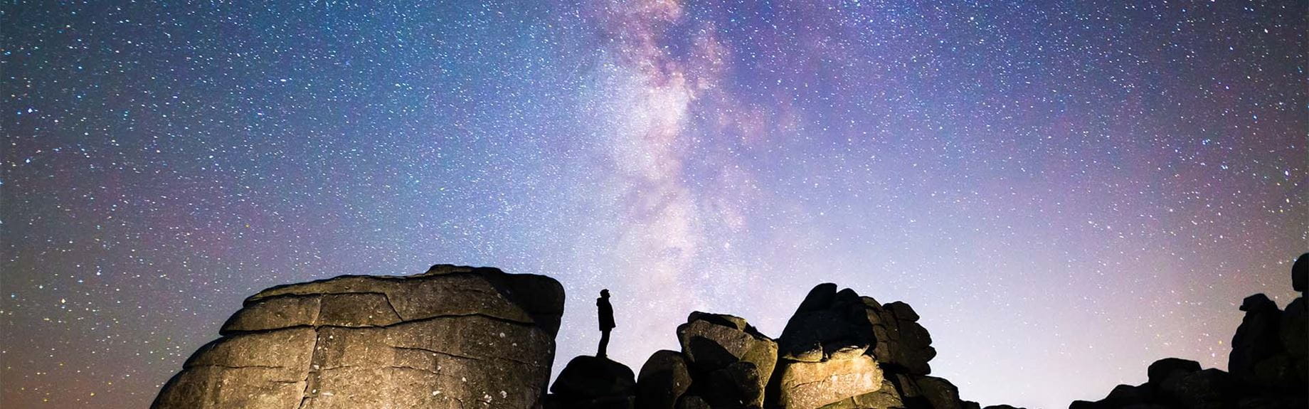 The milky way visibile in the sky behind a rock formation