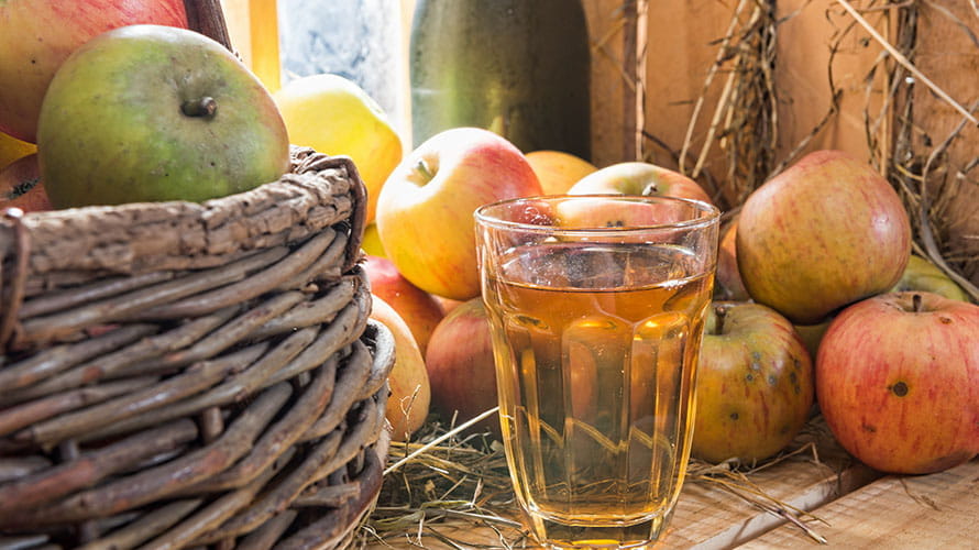 A glass of cider and some apples