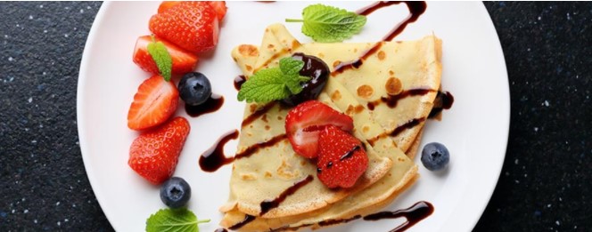 Crepes with fruit and icing sugar