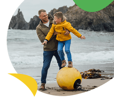 A father and son playing on the beach on a rainy day