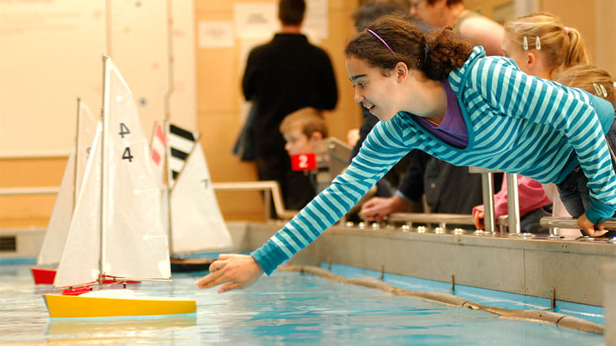 A girl pushing a model boat at Cornwall's Maritime Museum