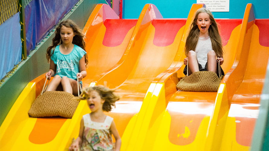 Children going down a slide at a soft play centre