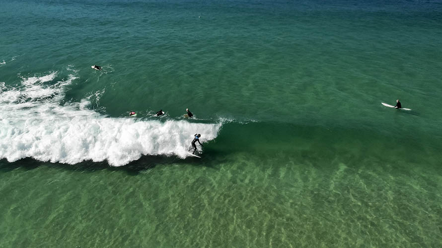 Surfers lining up to catch the perfect wave on Fistral Beach in Newquay