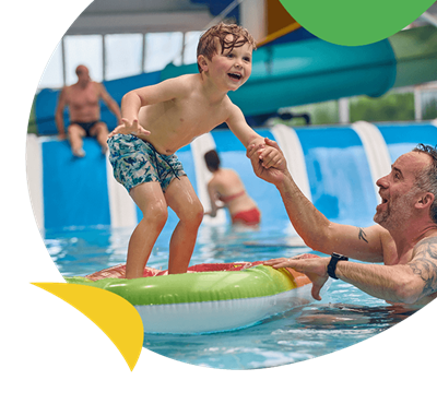 A boy standing on a float in a pool