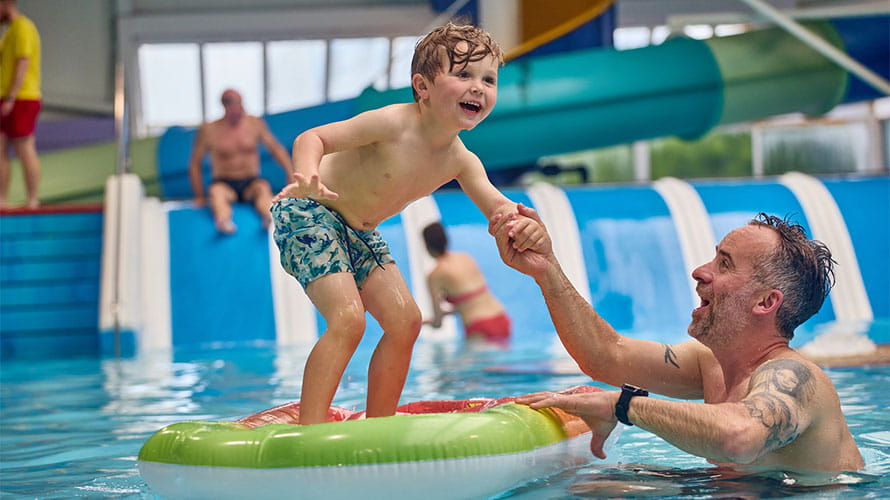 A family splashing in an indoor pool