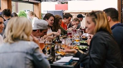 A group of people enjoying food and drinks in a restaurant