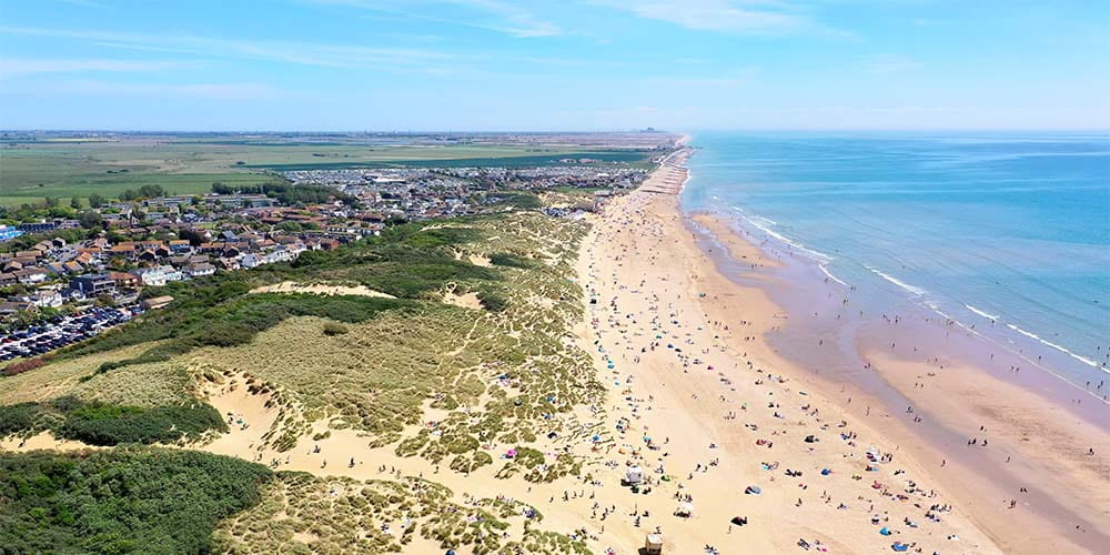 An aerial view over Camber Sands Beach on a summer day