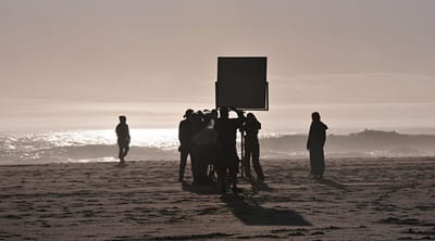 crew and cast filming on a beach