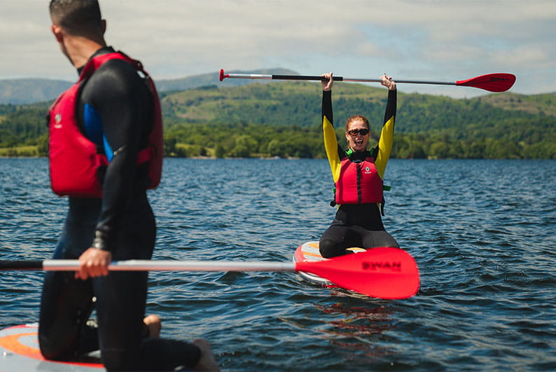 Friends paddleboarding on Lake Windermere in the Lake District