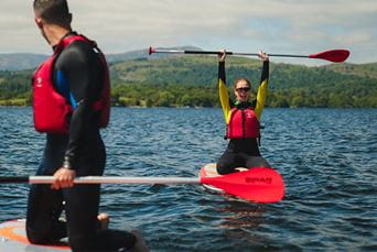 Friends paddleboarding on Lake Windermere in the Lake District
