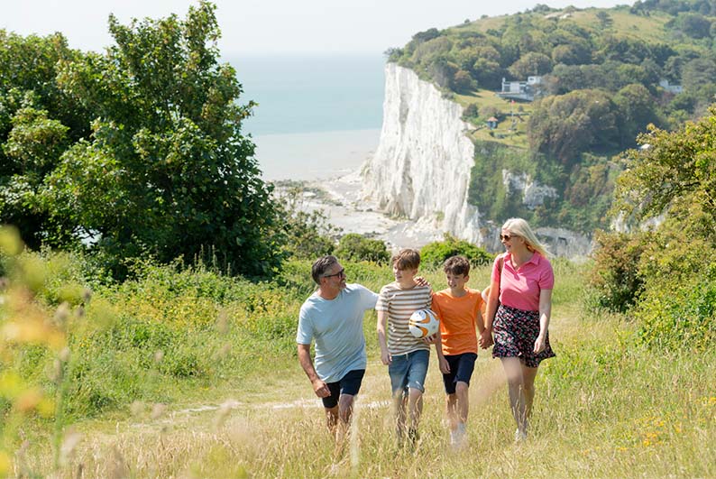A family walking along a coastal path by the White Cliffs of Dover