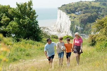 A family walking along a coastal path by the White Cliffs of Dover