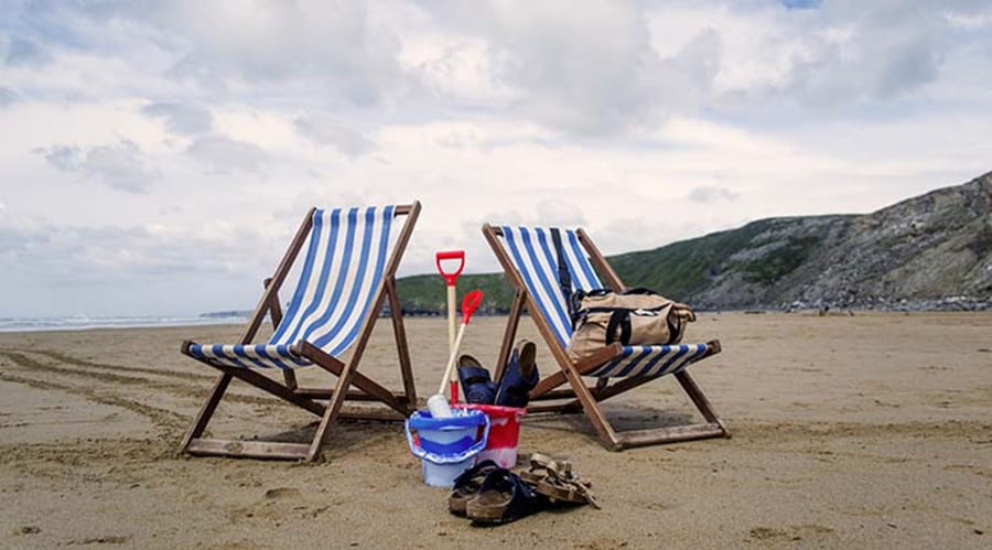 Deck chairs and buckets and spades on a beach